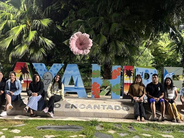 Viajeros frente a las letras turísticas de un destino dominicano